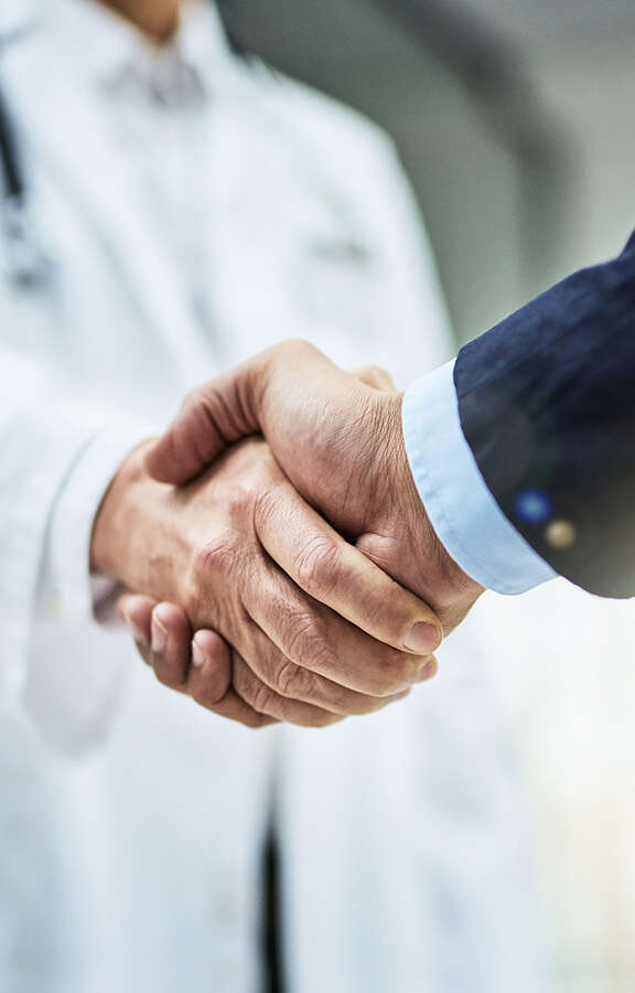 Doctor and man in suit shaking hands